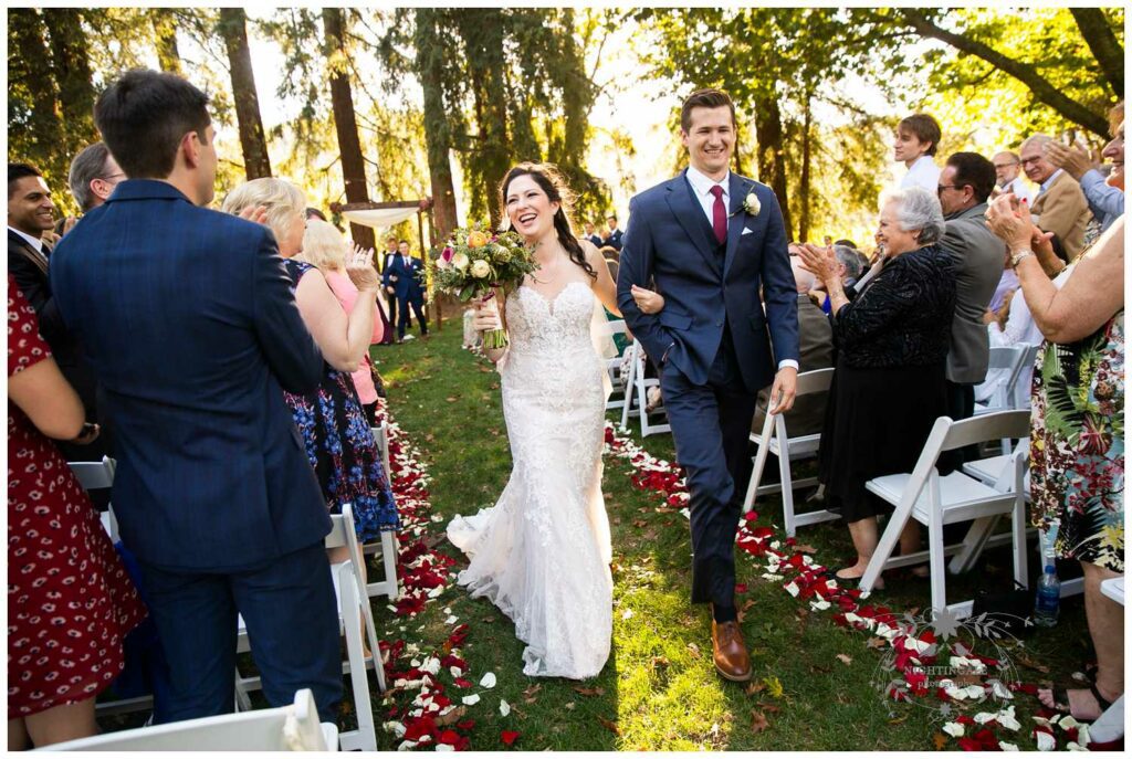 couples leaves their napa valley wedding ceremony with guests cheering