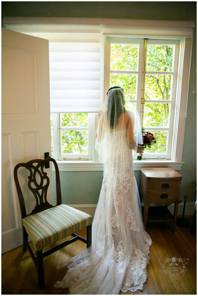 Bride looks out a window before her wedding at Charles krug winery
