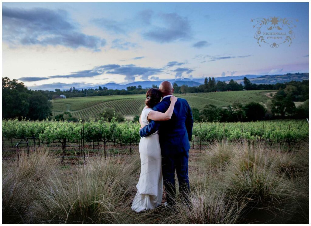 Couple looks over the Sonoma Valley with sunset at their wedding reception