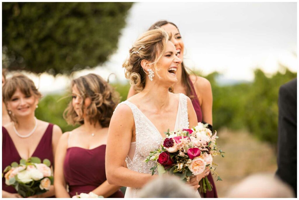 beautiful brides laughs during the ceremony at winery wedding