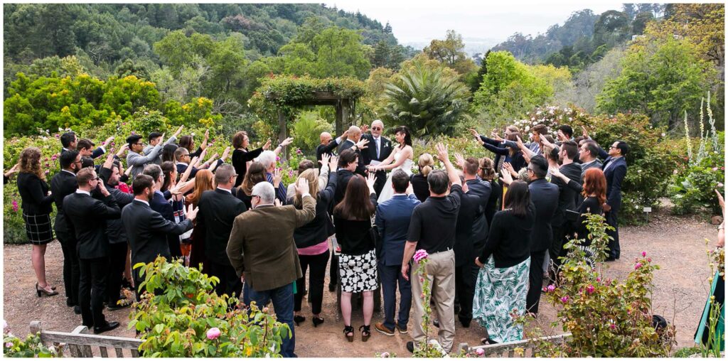 a crowd gathers around a small wedding at the UC botanical gardens