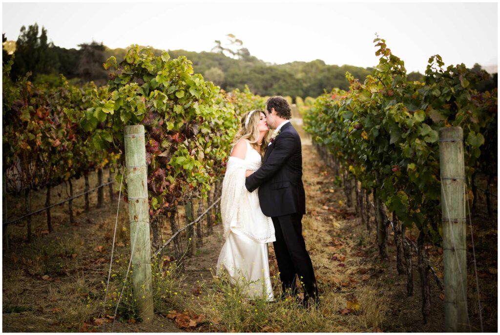 married couple pose of wedding photos in vineyard from carmel valley resort, Bernardus Lodge by elopement photographer nightingale photography