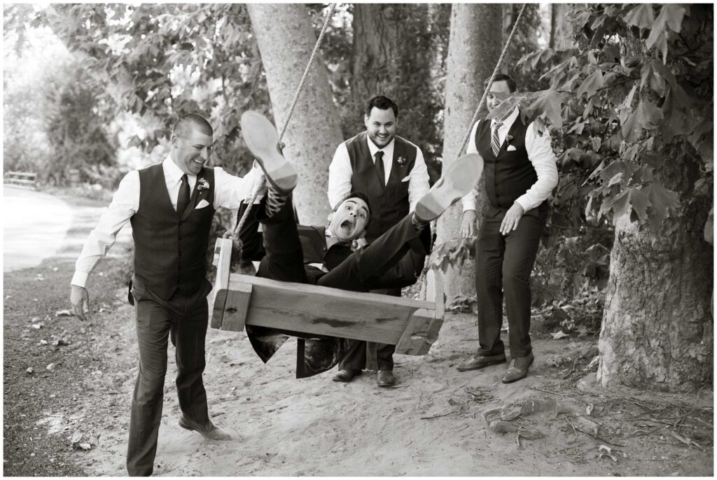 funny photo of groom on swing with groomsmen in santa barbara
