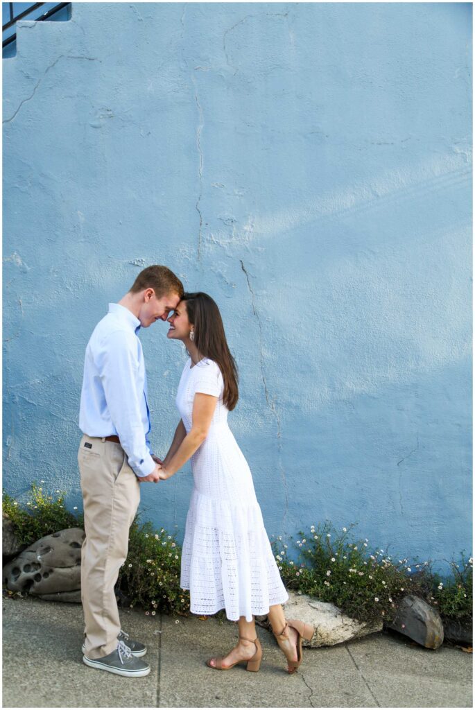sweet engagement photo with blue wall in san francisco