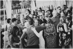 bride hugs guests after her backyard rustic wedding