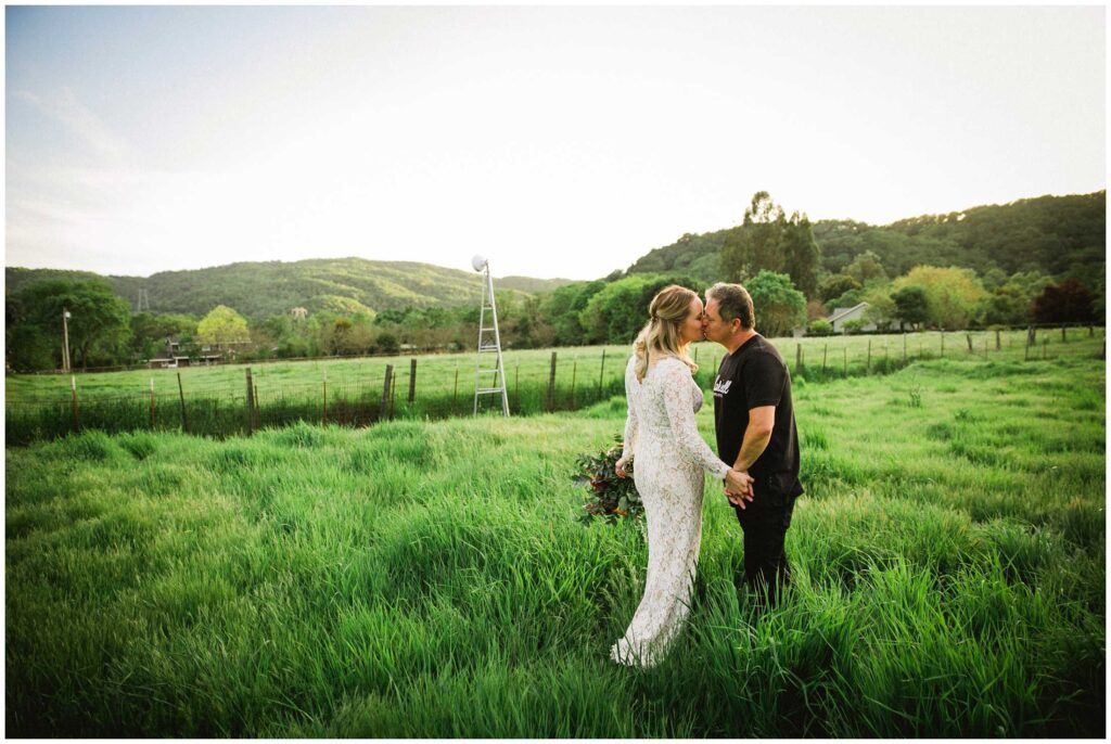 newly married couple in northern california has a kiss in their field