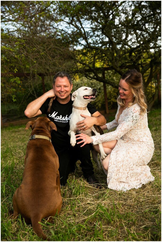 newlyweds kiss their dogs after their rustic and intimate wedding