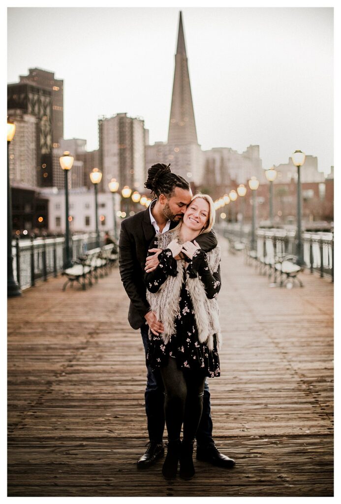 couple hugging at twilight on pier 7 in san francisco